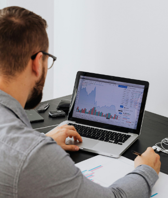 A professional man working on data visualizations on his laptop