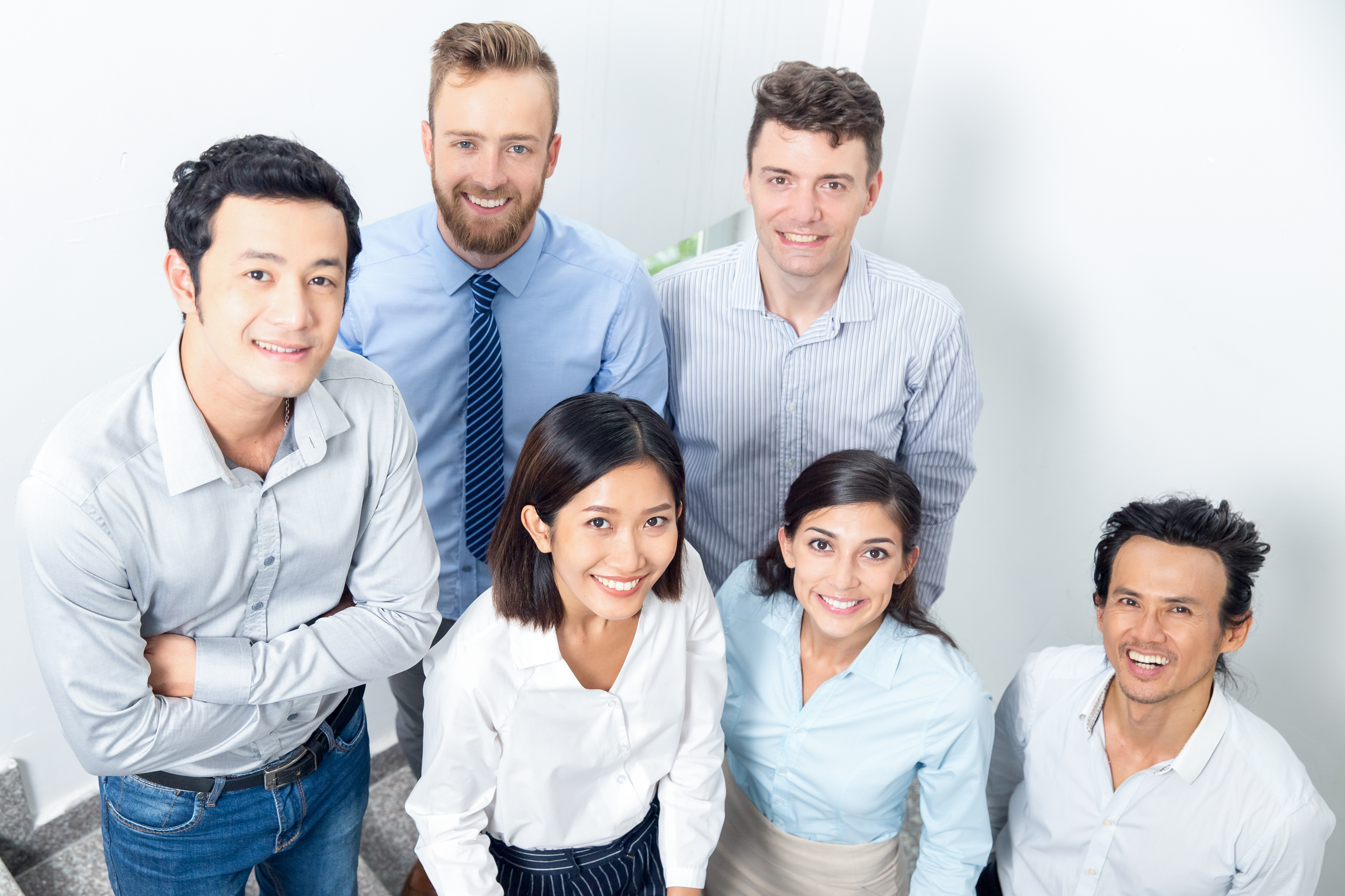 A team of 6 professionals looking up at the camera