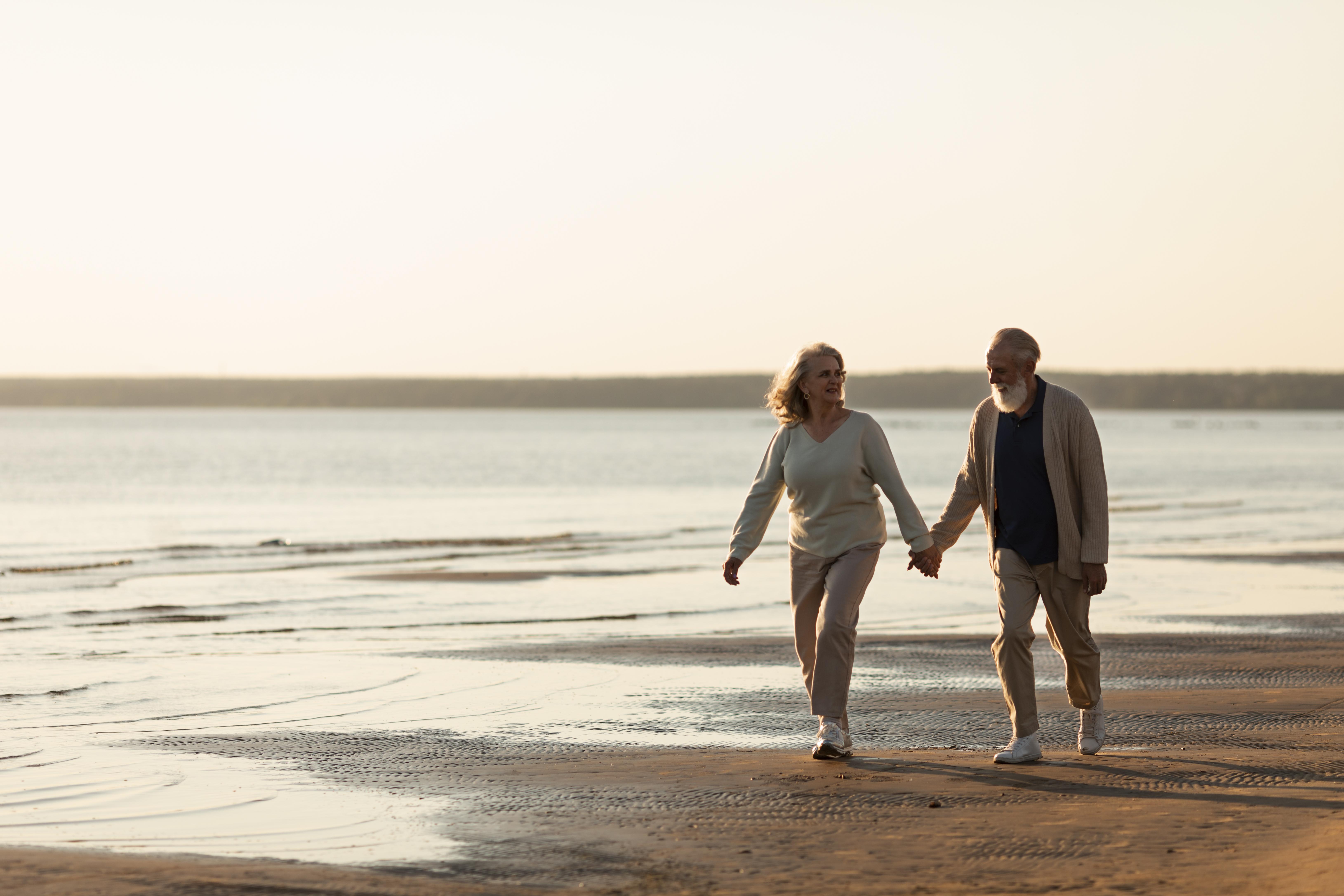 An elderly couple walking at the beach