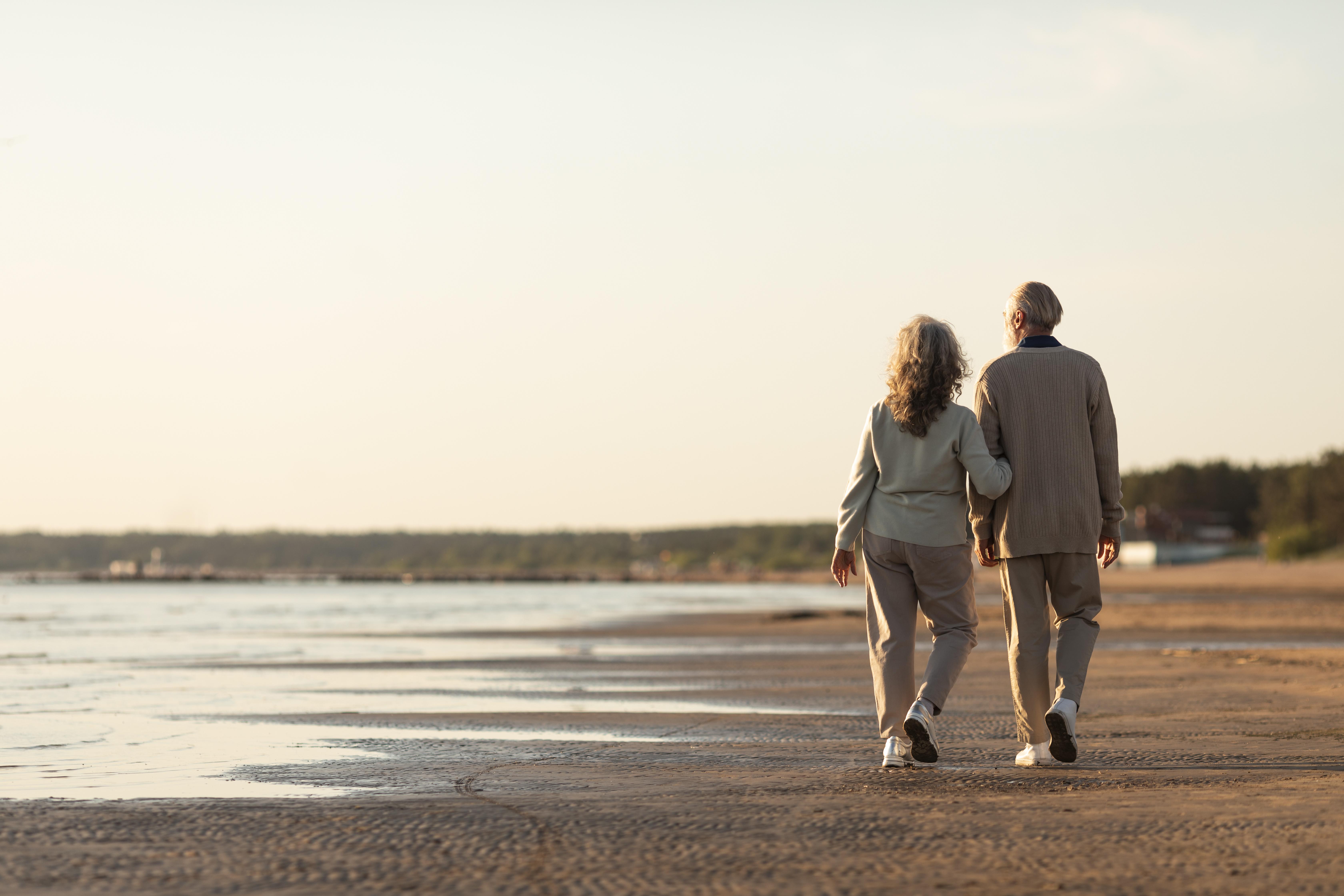 An elderly couple walking at the beach