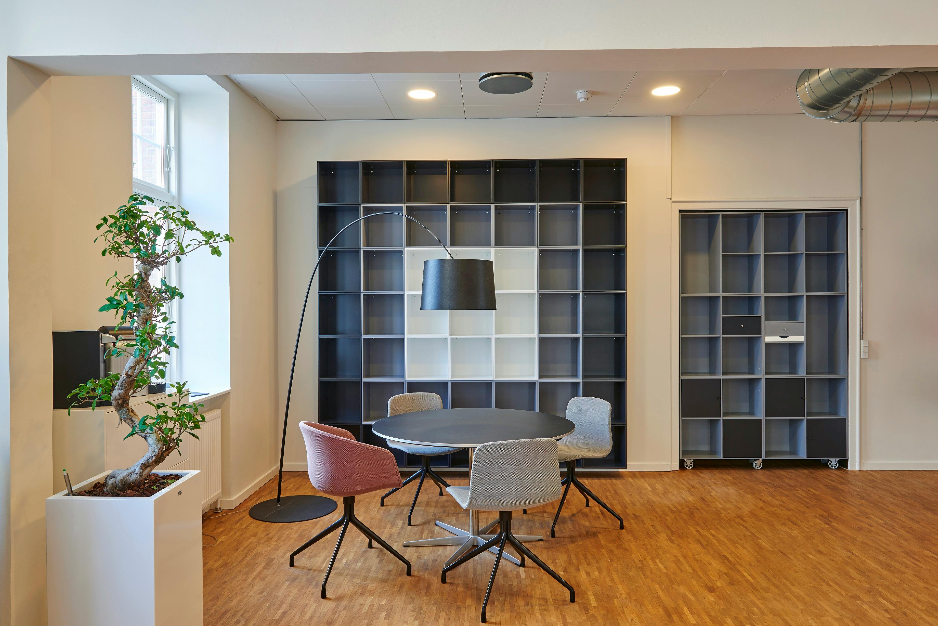 A reading or discussion room with bookshelves, a round table and 4 chairs